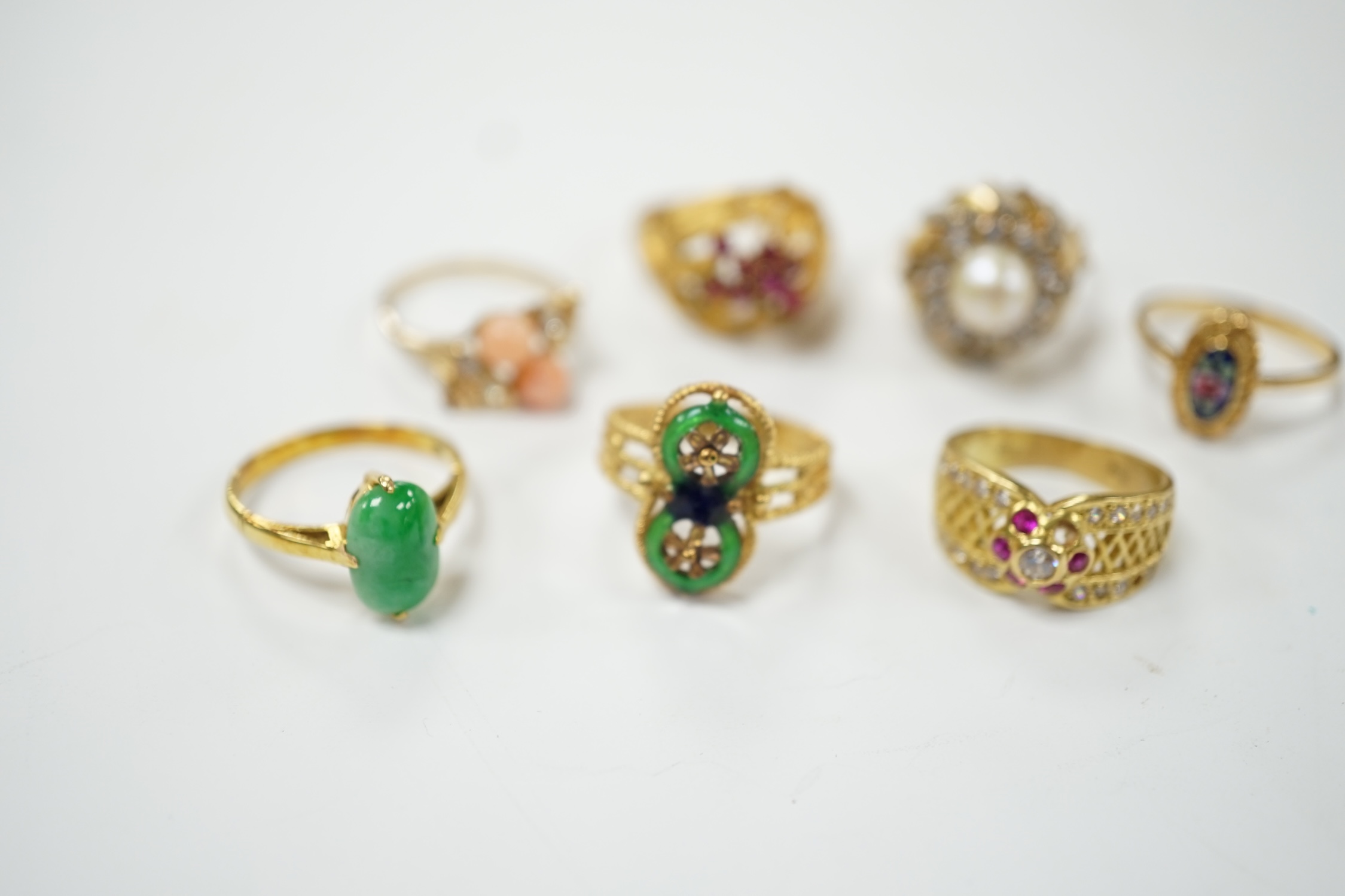 A Middle Eastern 750 yellow metal and two colour enamel up-finger ring, size M, a Chinese 750 yellow metal and gem set cluster ring, gross weight 9.4 grams, a 14k and jade set ring, gross weight 2.8 grams and three assor